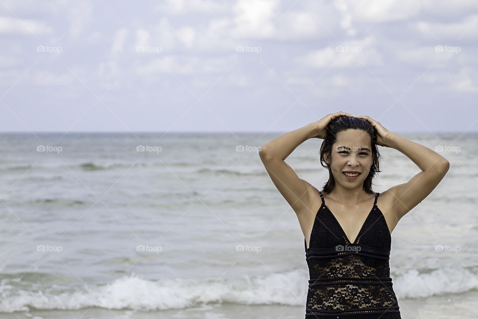 Portrait of Asian woman wearing a swimsuit background sea and sky