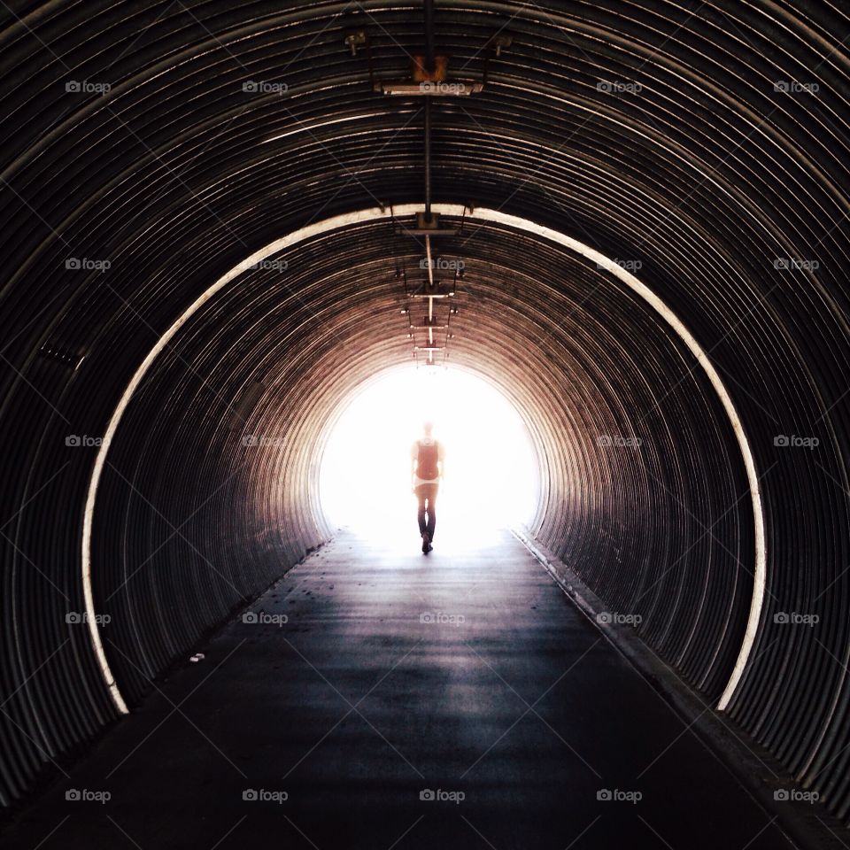 Silhouette man standing in tunnel