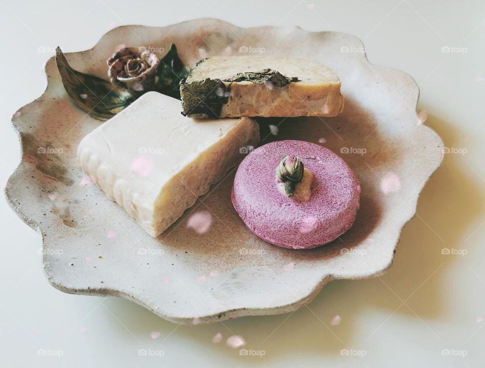 Soap and shampoo bars on a ceramic plate