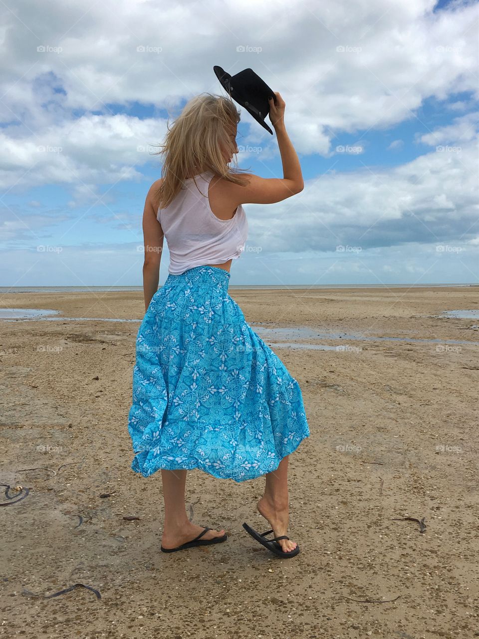 Rear view of woman putting on a hat