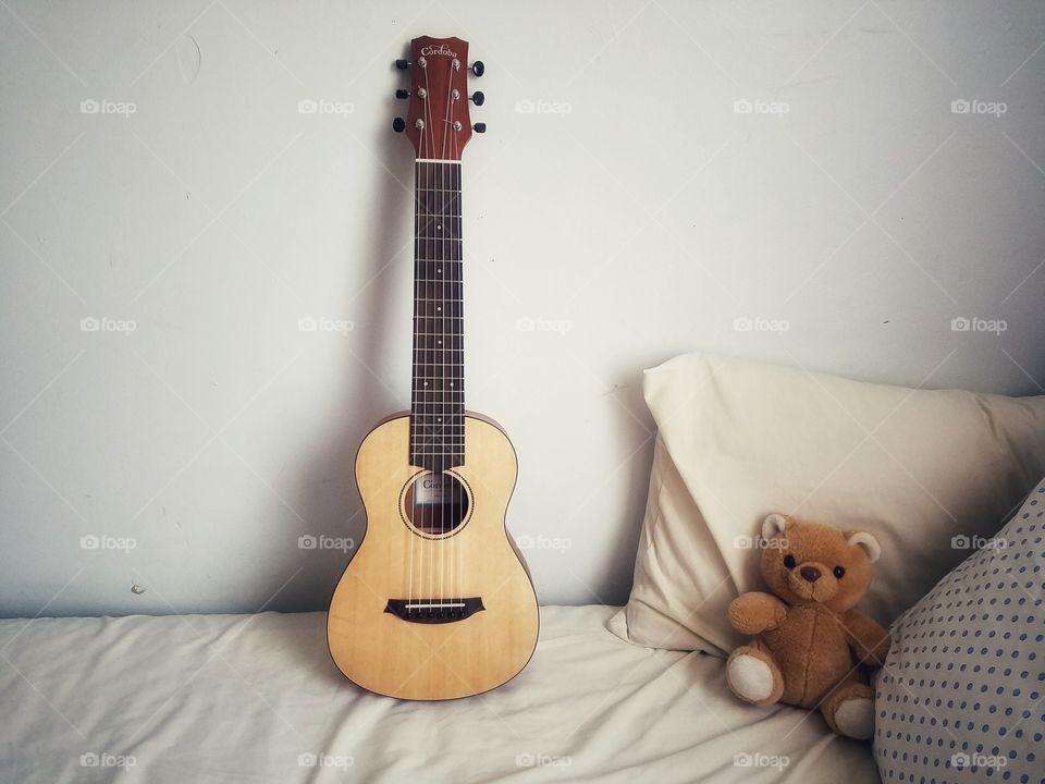 Cordoba Mini M and Teddy Bear on a bed