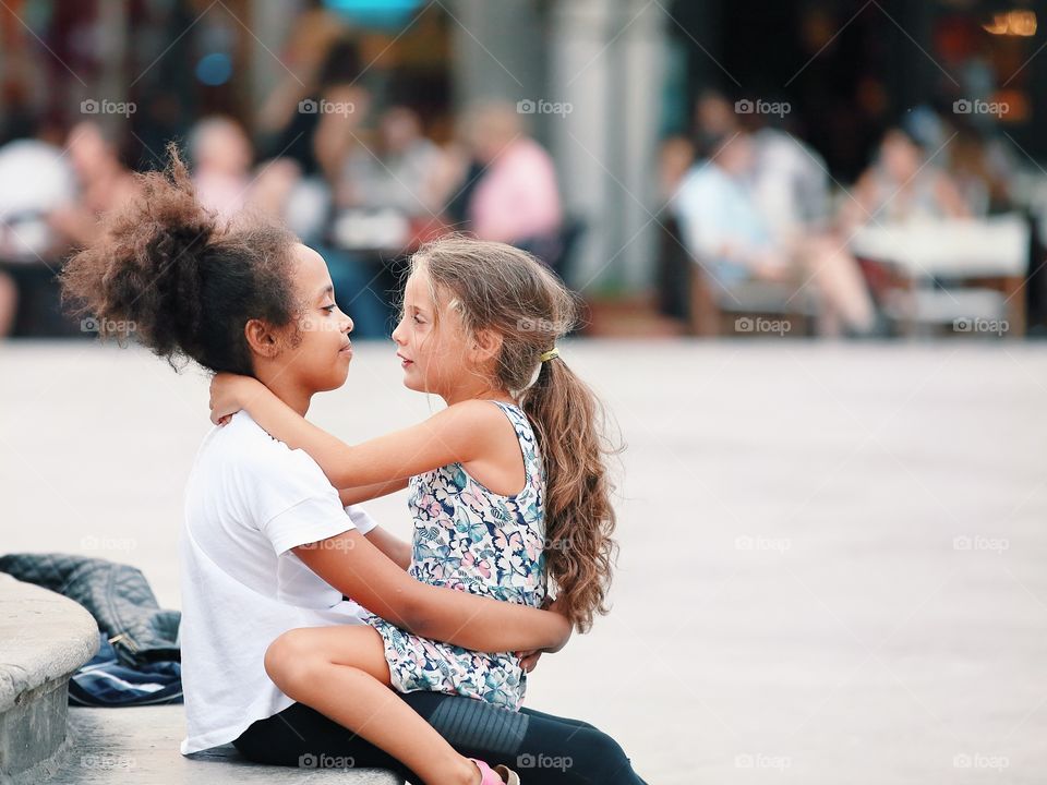 Two little cute smiling girl in a conversation