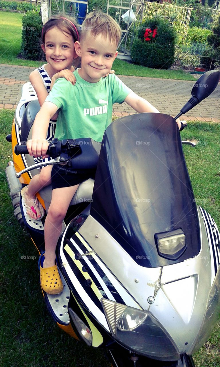 Twins on a motor scooter