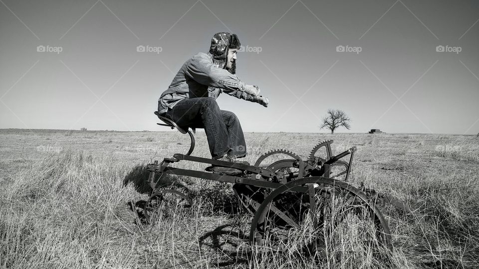 Man sitting on old agricultural vehicle in field