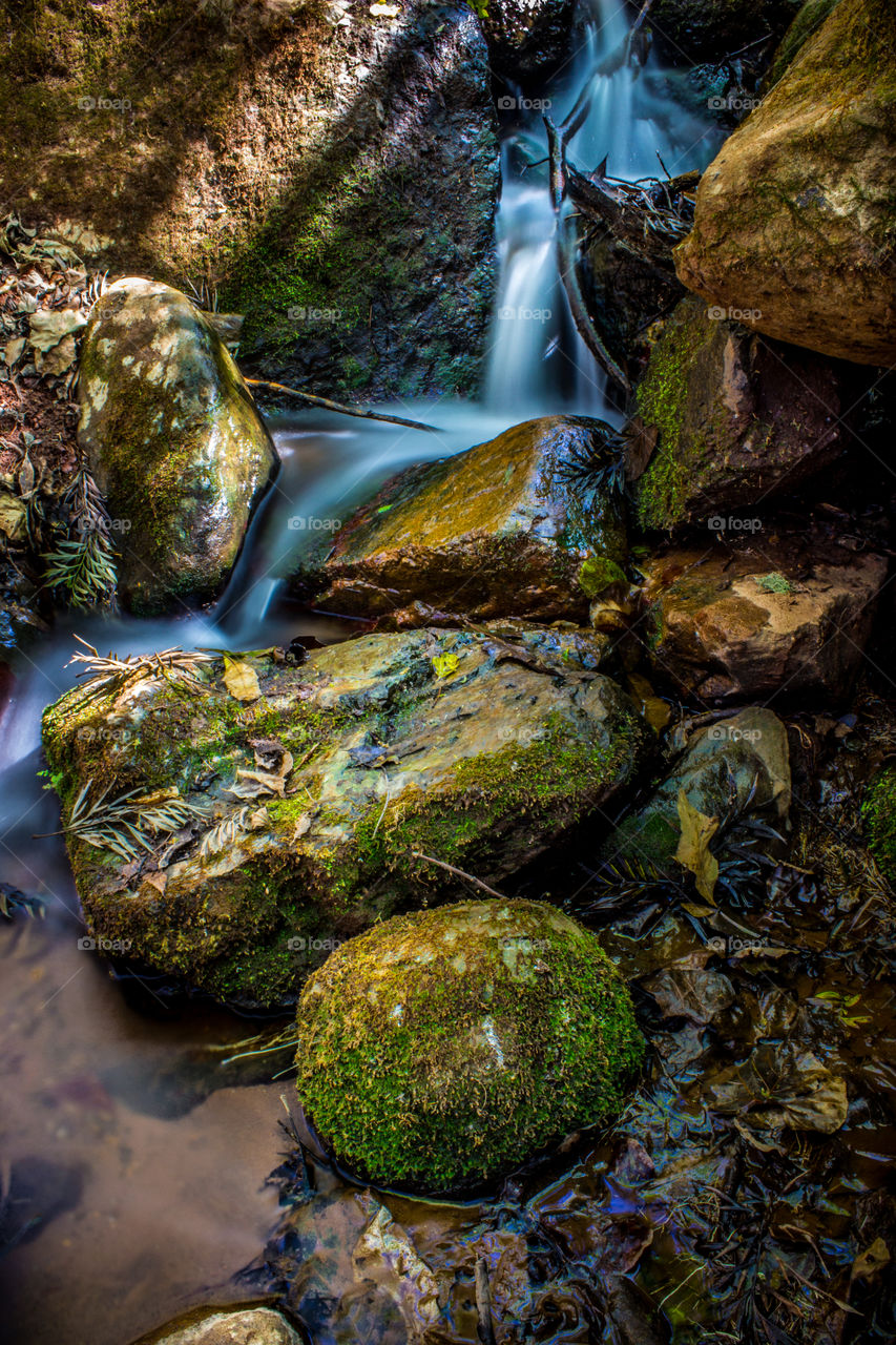 water running down some green moss rocks