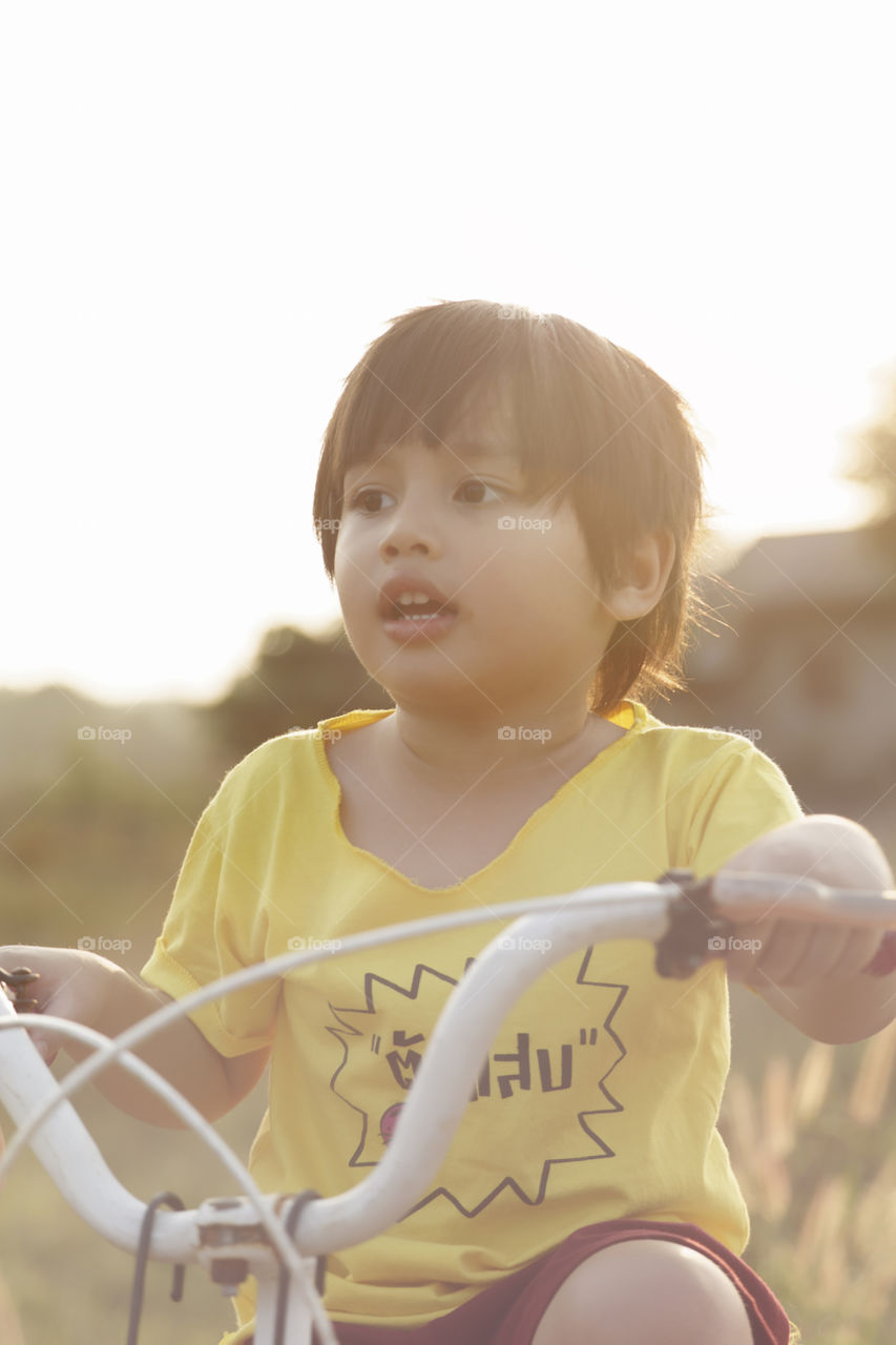 Kid riding bicycle. during golden hour on a sunny summer afternoon