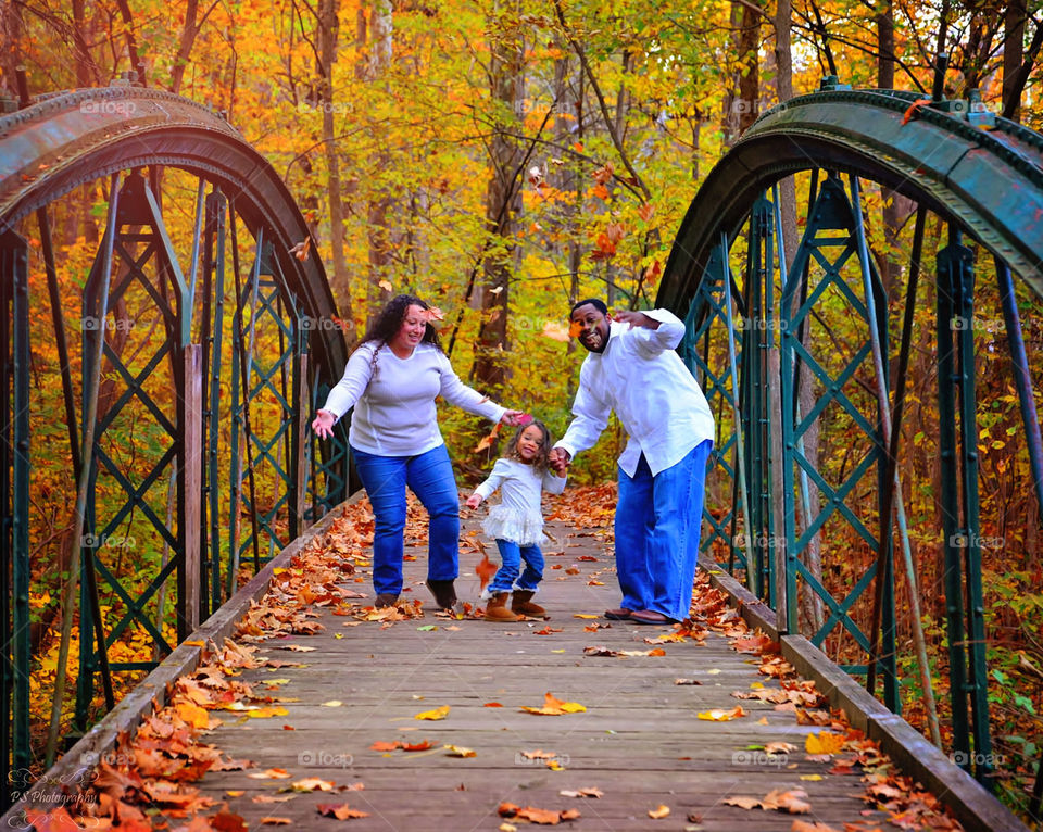 Family on boardwalk in the park during autumn