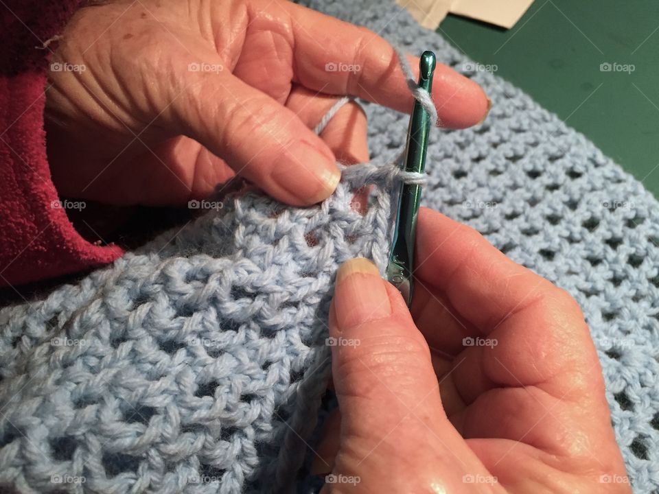 Grandma's hands crocheting something to keep warm.