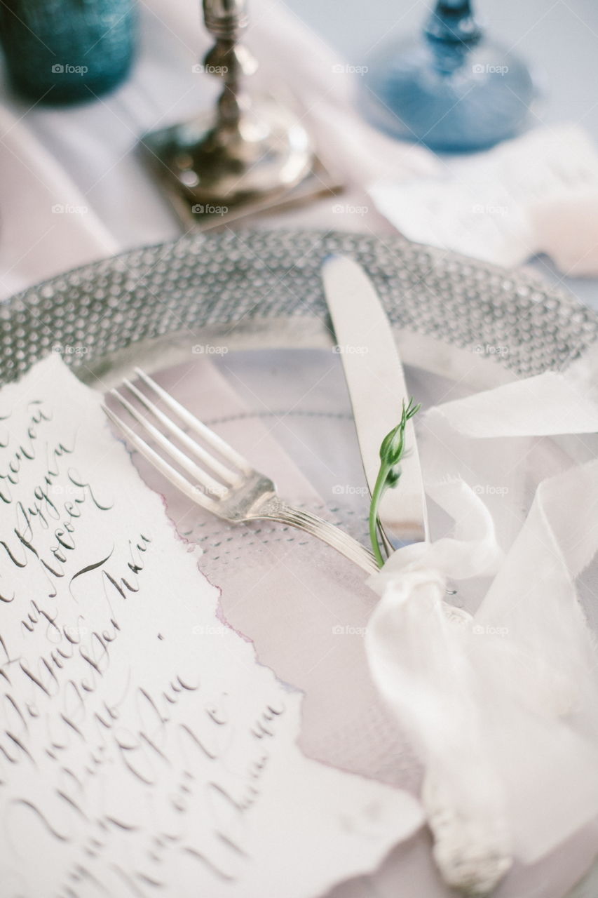 Graphic arts of beautiful wedding calligraphy cards and silver plate with cutlery on festive wedding table. 