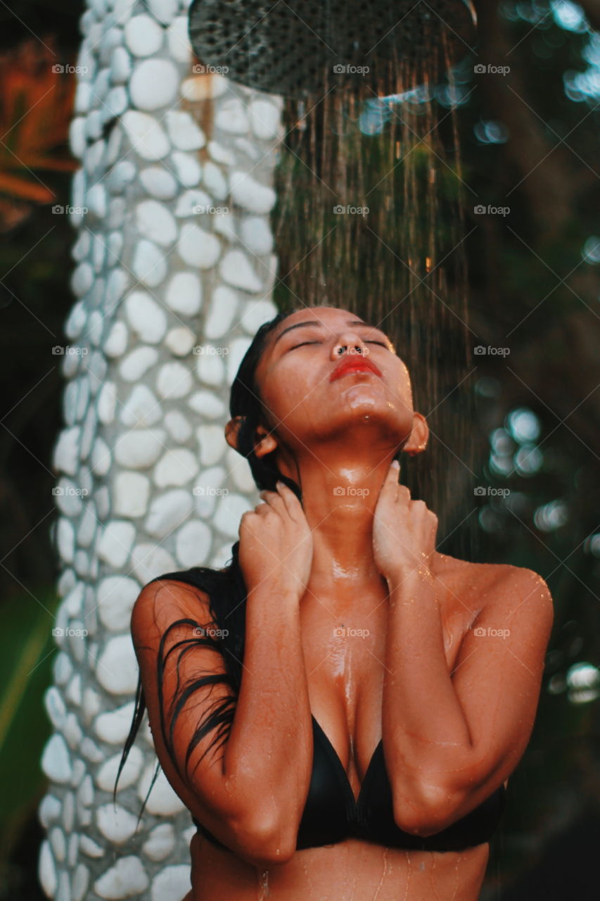 tanned girl wearing bikini is showering after swimming