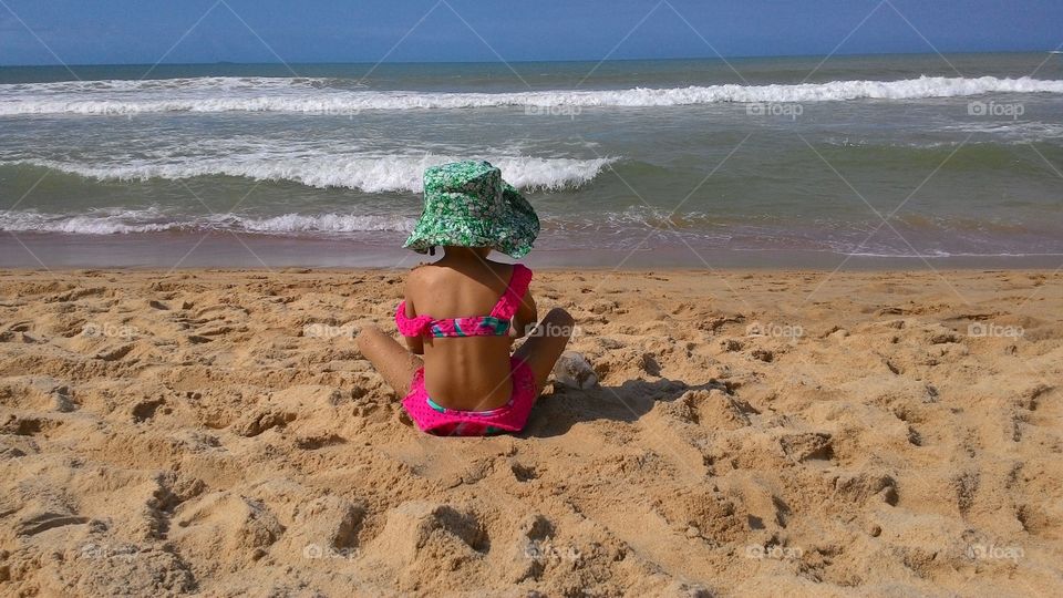 Girl playing in the sand on the beach