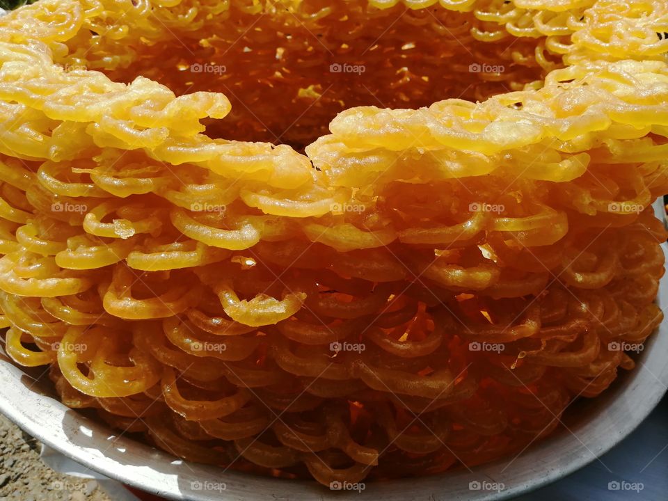 Jalebi, also known as zulbia and zalabia, is an Indian sweet and popular food found all over South Asia and the Middle East. It is made by deep-frying maida flour  batter in pretzel or circular shapes, which are then soaked in sugar syrup.