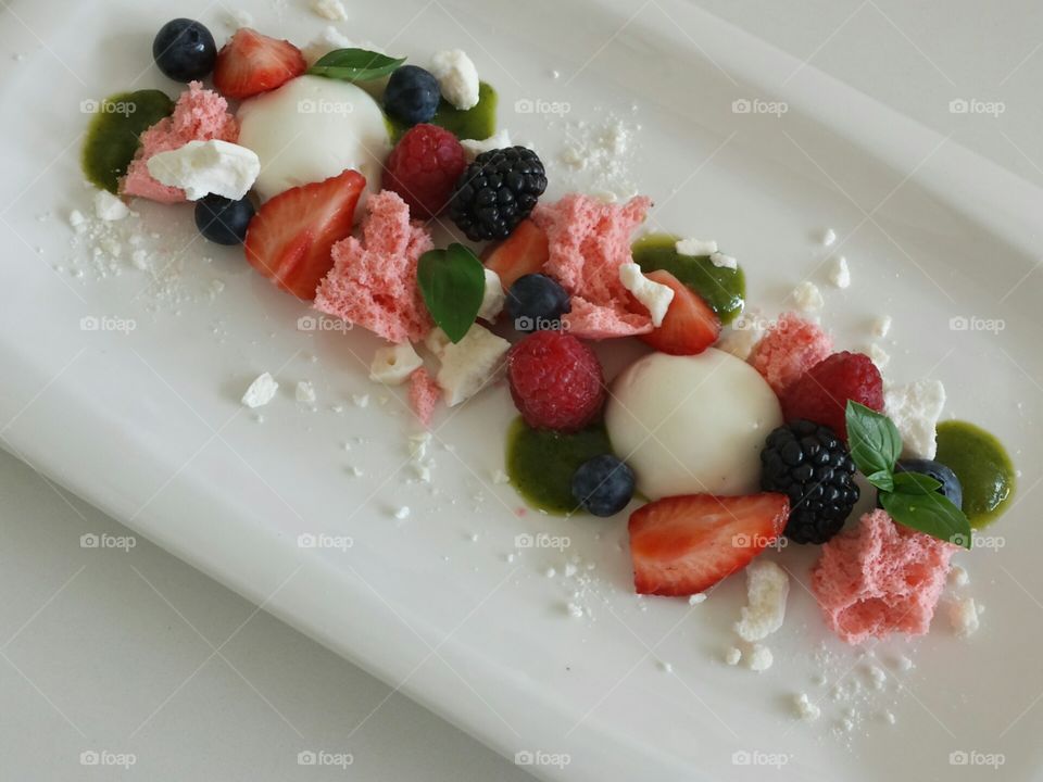 Summer on a plate. berries with spongecake, merengue, basil and ricotta 