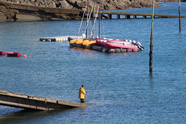 Observer et découvrir un pêcheur au bord de la mer