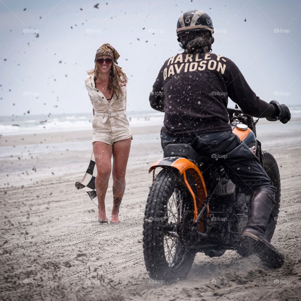 Woman looking at a person riding bike at beach