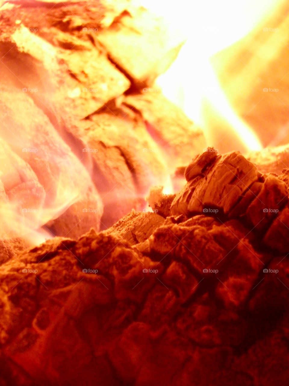 Warm cozy detailed close up of log fire and glowing coals. 