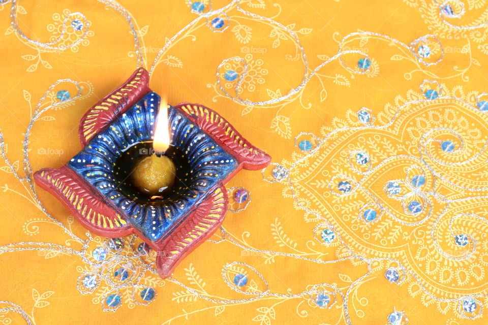 Diwali diya on yellow embroidery textile