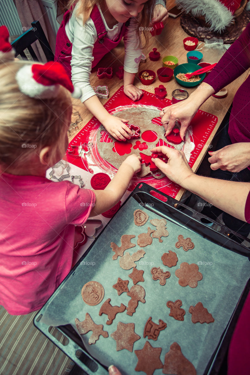 Baking Christmas cookies. Christmas gingerbread cookies in many shapes decorated with colorful frosting, sprinkle, icing, chocolate coating, toppers, put on table. Baking traditional cookies. Family celebrating Christmas. Baking at home