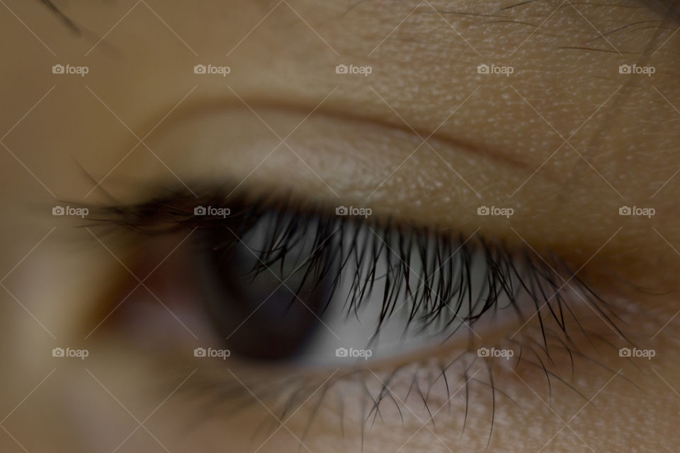 macro close up of deep black eye almond shape of a young Asian boy