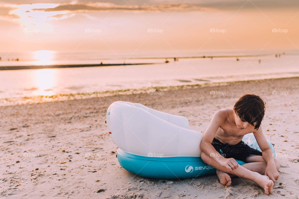 Young boy playing with sand on the beach 