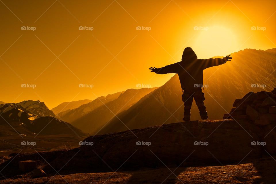 rear view of a man enjoying the magical mountain landscape, golden hour