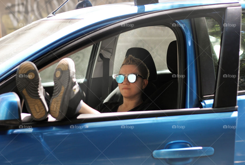 A woman sitting in blue car