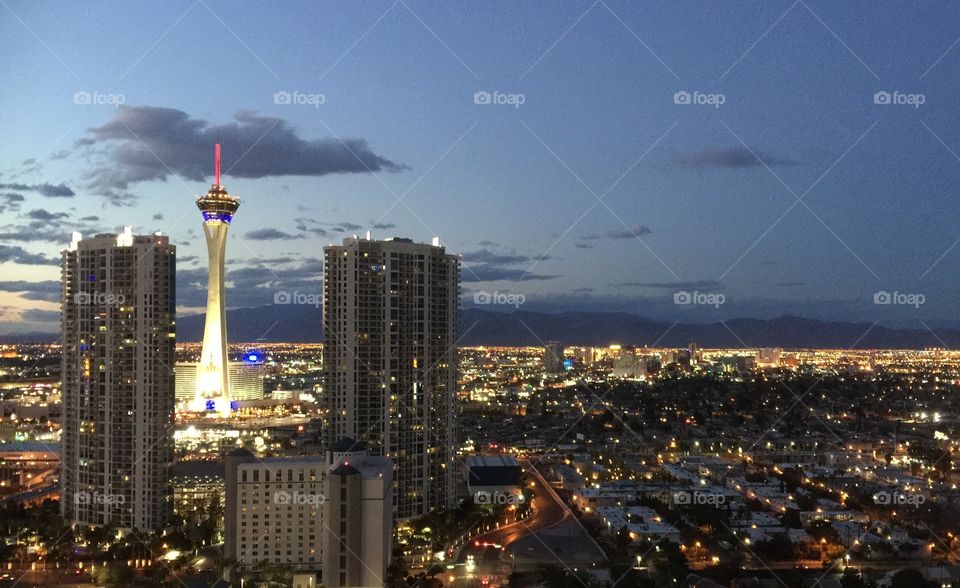 A view of the Las Vegas skyline looking towards the Stratosphere Tower at dusk. Evening lights and view of The Strip.