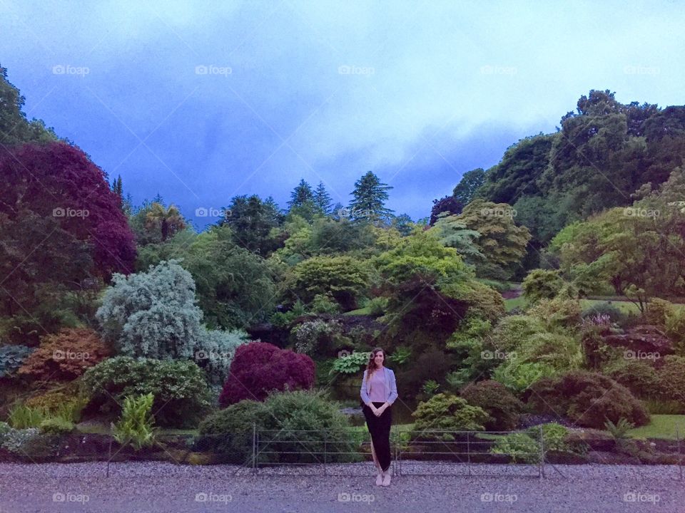 Woman standing in front of trees