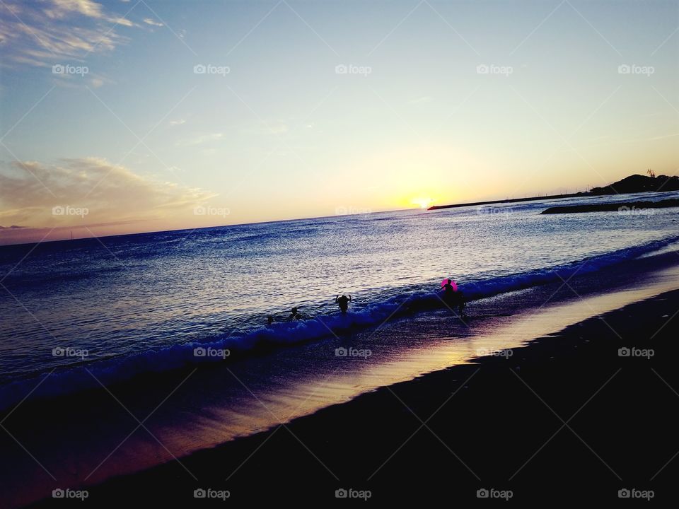 Kids playing in the ocean as the sun hoes down at Pokai Bay