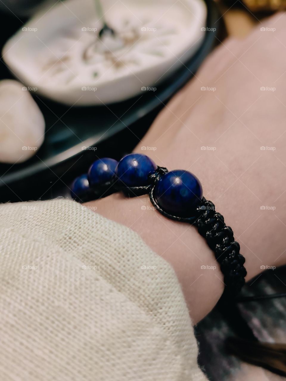 Deep blue lapis lazuli gemstone woven shamballa bracelet, natural round shape stone bracelet on woman's wrist close up