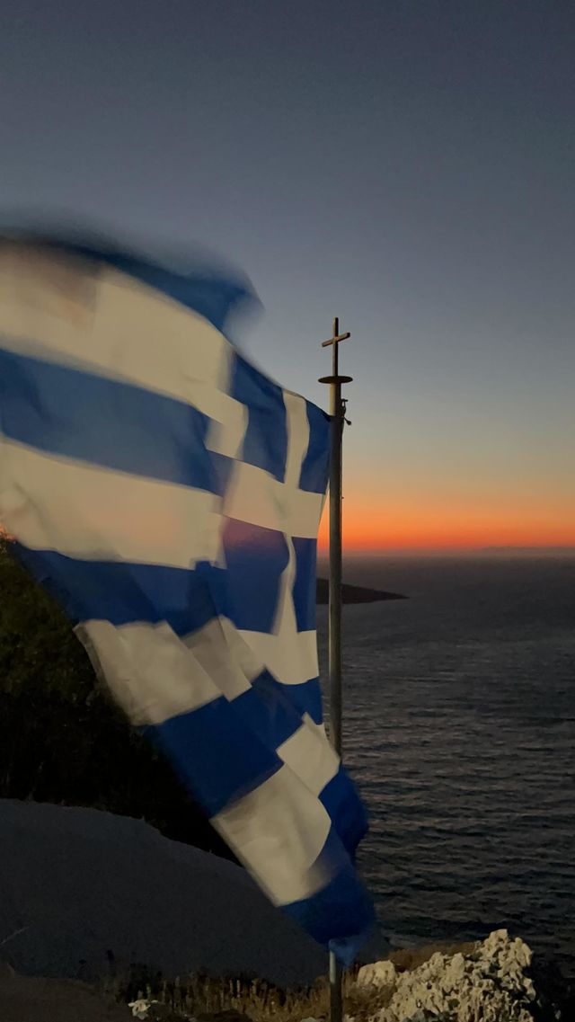 The Greek flag with the Aegean in the background
