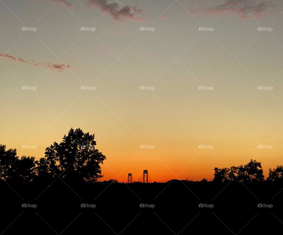 Silhouette of the Verrazzano-Narrows Bridge on the distant horizon at sunset
