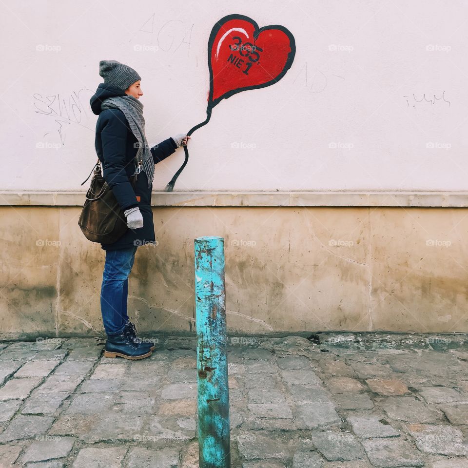 Woman holding painted balloon on wall