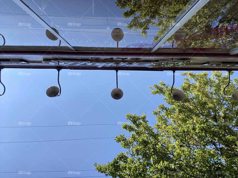 An upside down view outside one of my favorite eating spots. Sitting outside looking up at the sign, light fixtures, blue sky and trees outside Berritazza Cafe in Point Pleasant Beach, NJ. The cafe window reflects the scenery while I enjoy my shake! 