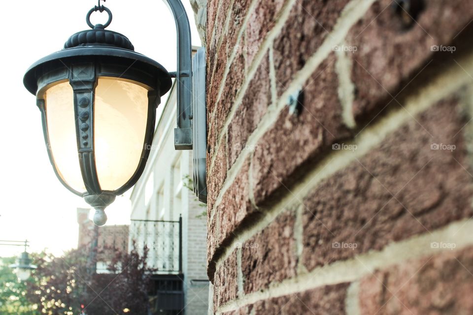 Street light against brick wall