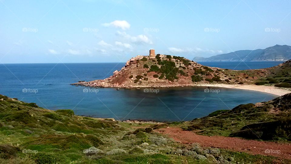 Cliff and ancient fortification tower ruins in north Sardinia