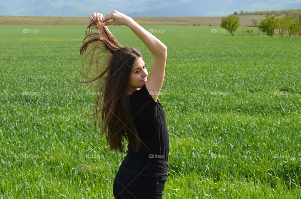 Woman with beautiful long hair on field background