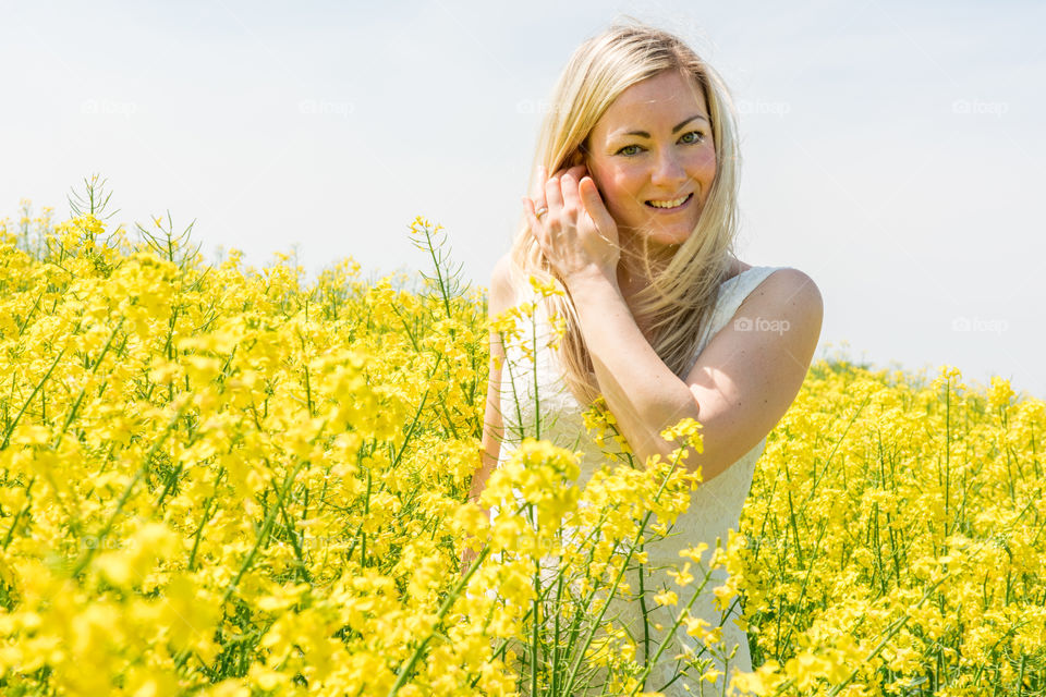 Woman 30 years old walking in a Raps field outside Malmö in Sweden.