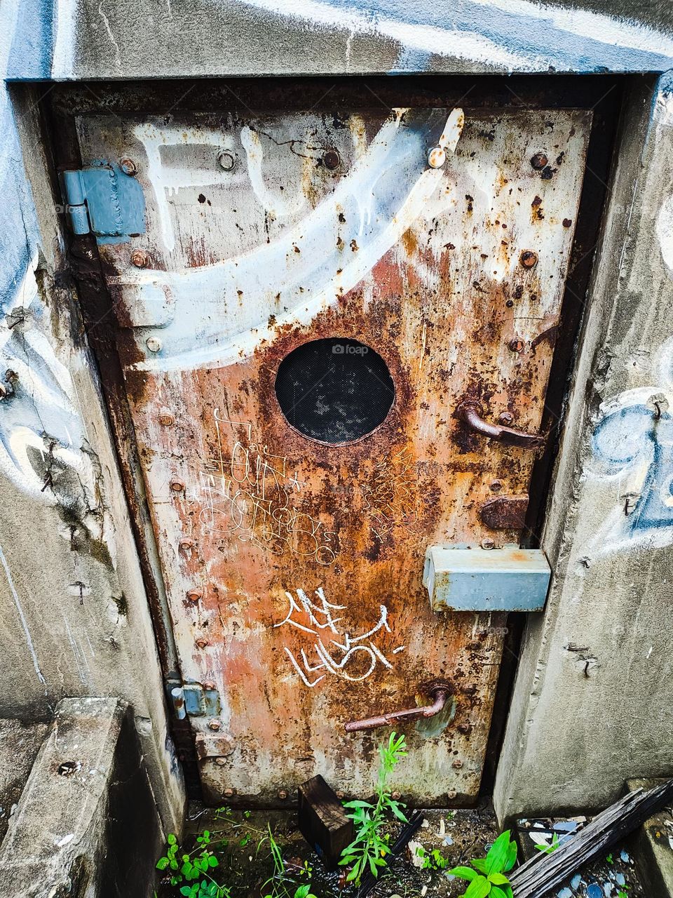 Old rusty metal door with graffiti