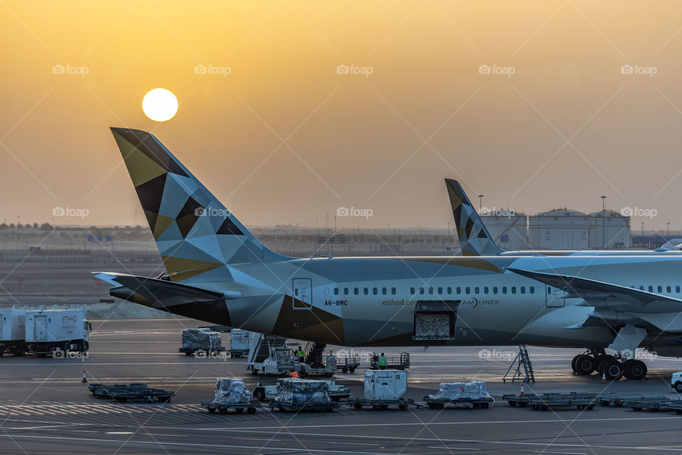 An Etihad Airways Dreamliner 787 at Abu Dhabi Airport during a beautiful sunrise.