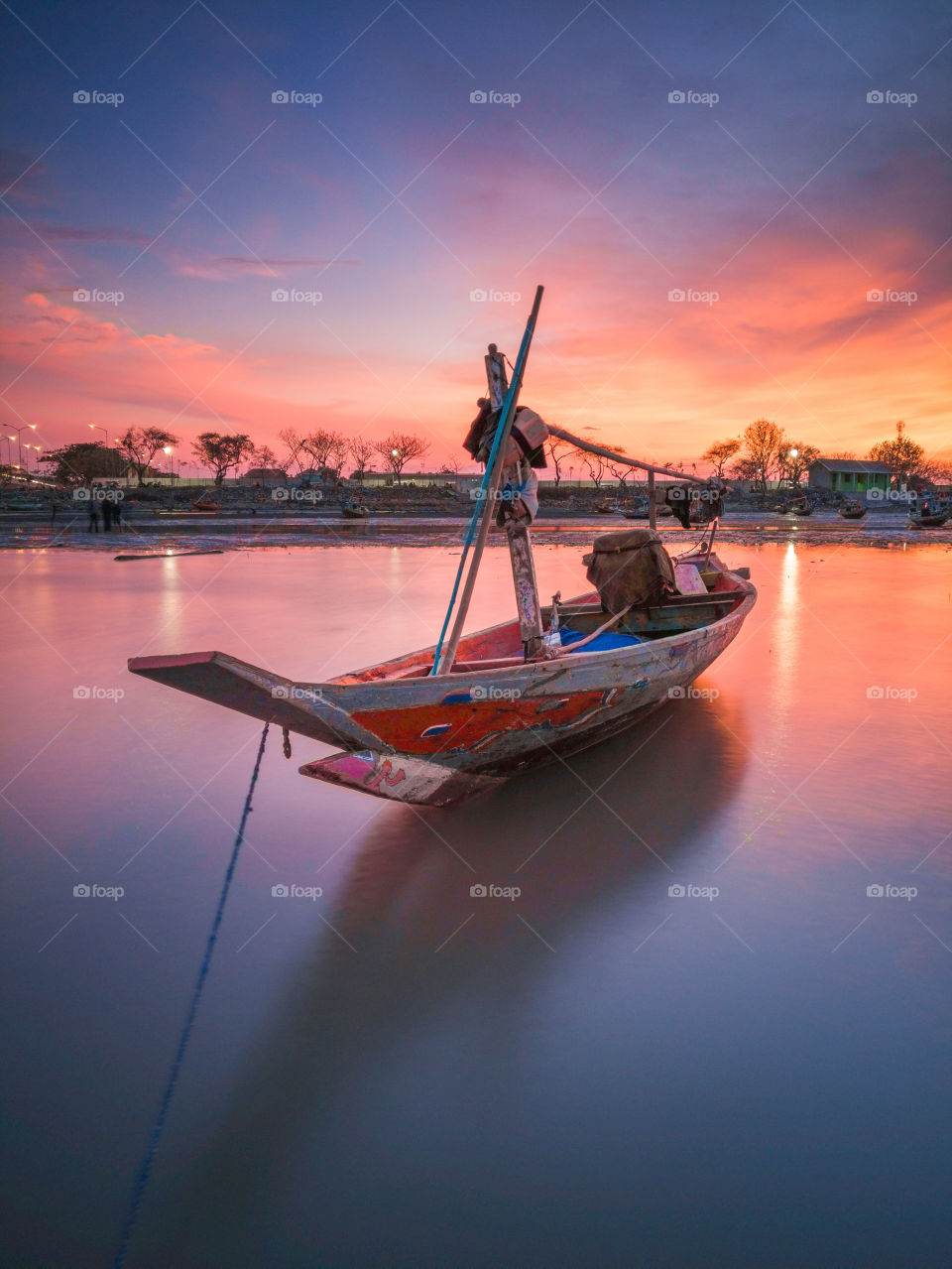 lonely boat during a sunset around suramadu