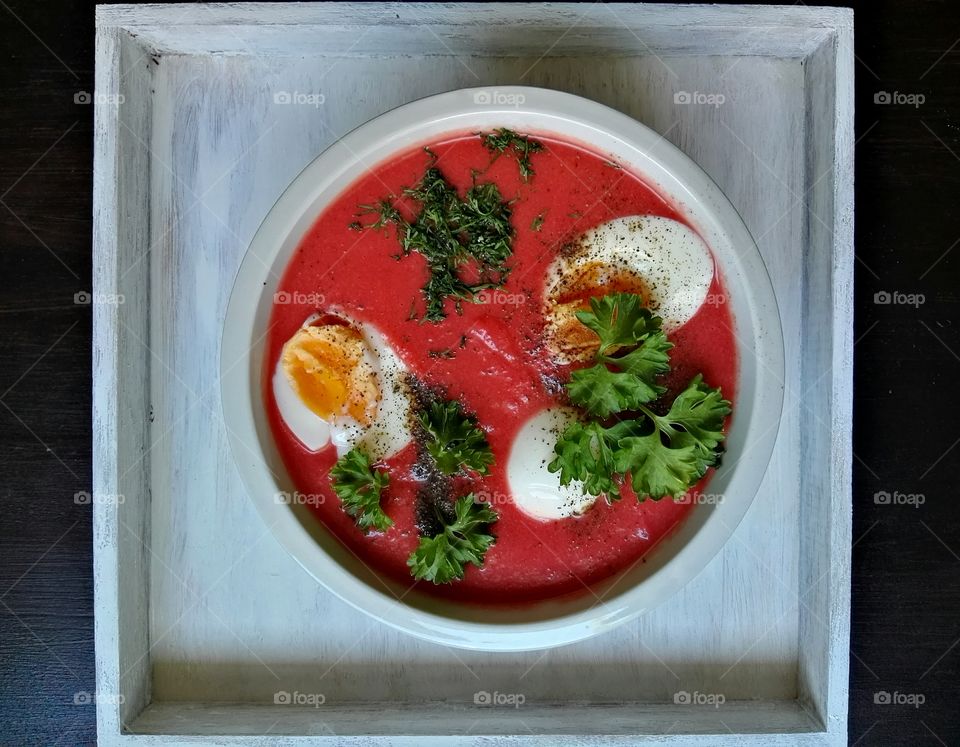 Red beet soup in a white bowl