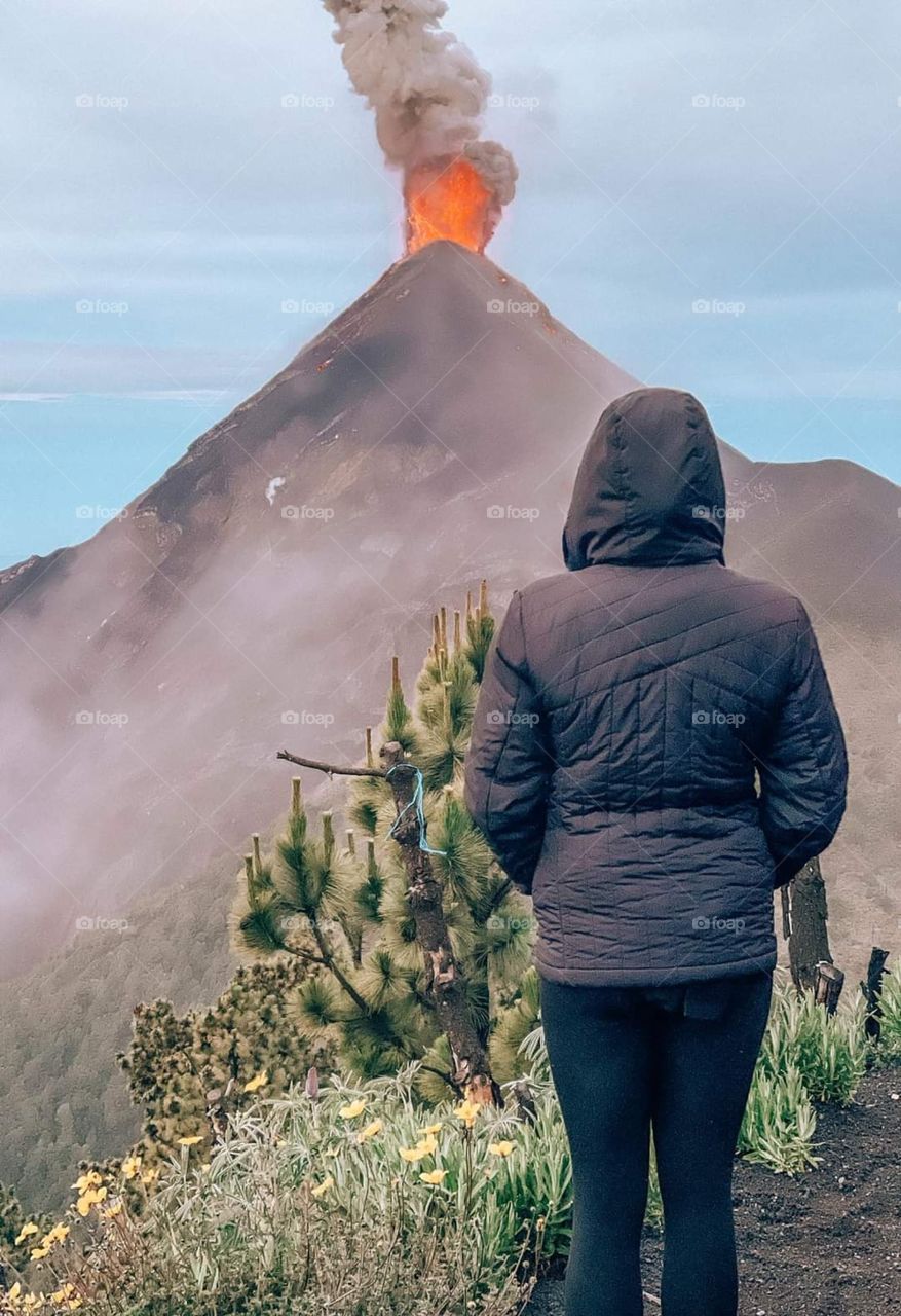 rear view of woman wearing a gray sweater near the volcano
