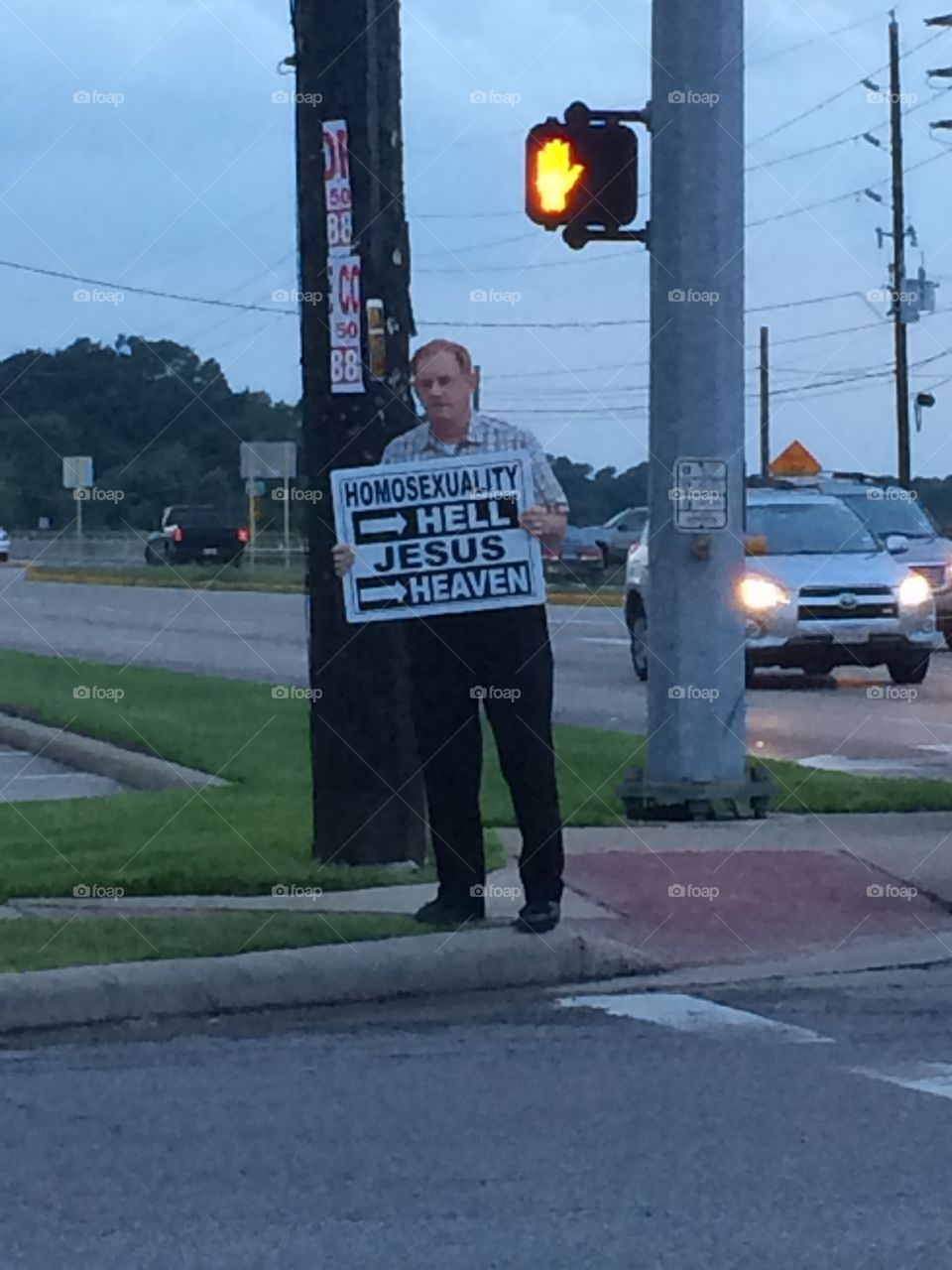 Dwina. Another photo of a men standing on the corner holding up sign.