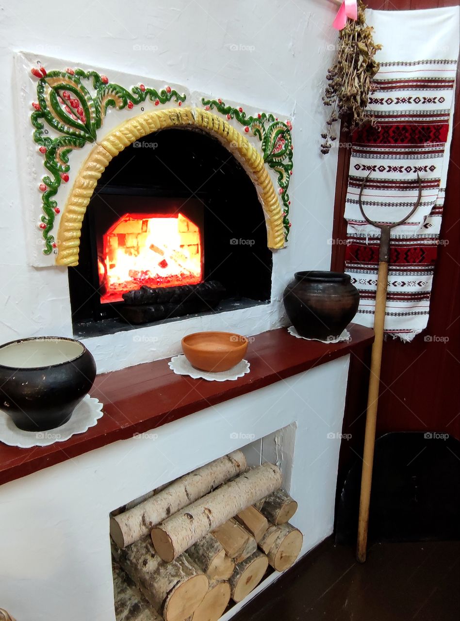 Russian stove, inside of which food was cooked in cast iron on the fire. In the lower part of the stove there is firewood for the firebox.  There are cast iron on the shelf.  In the corner there is a grip, with the help of which they pulled out ready