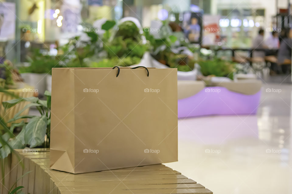 The brown paper bag for putting on a wooden seat.