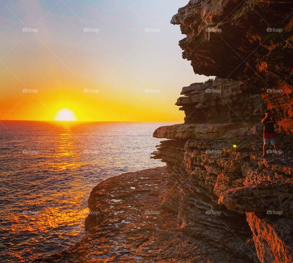 Sunrise over the sea at the rocky cliff