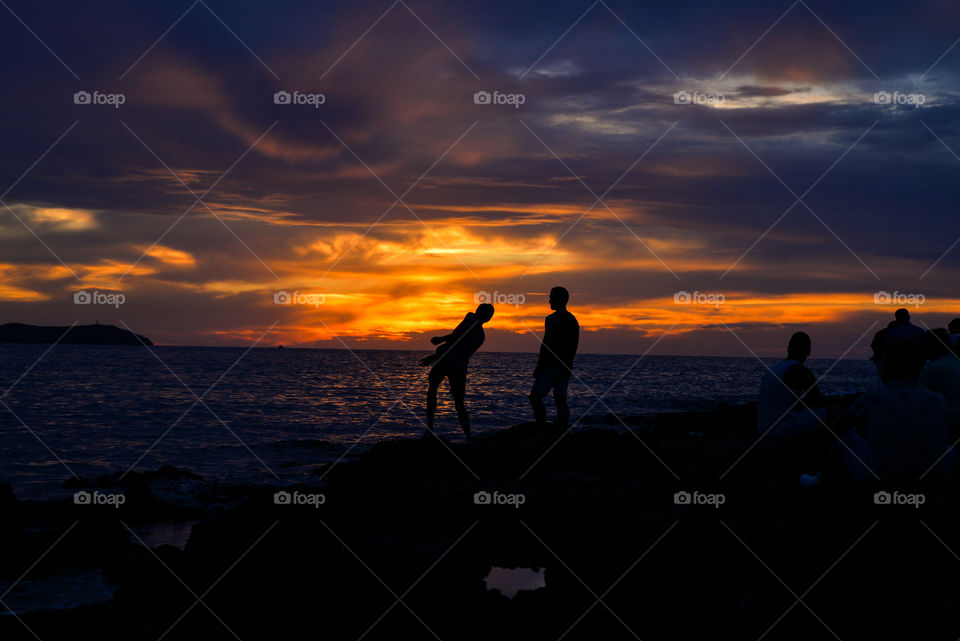 People at beach during sunset