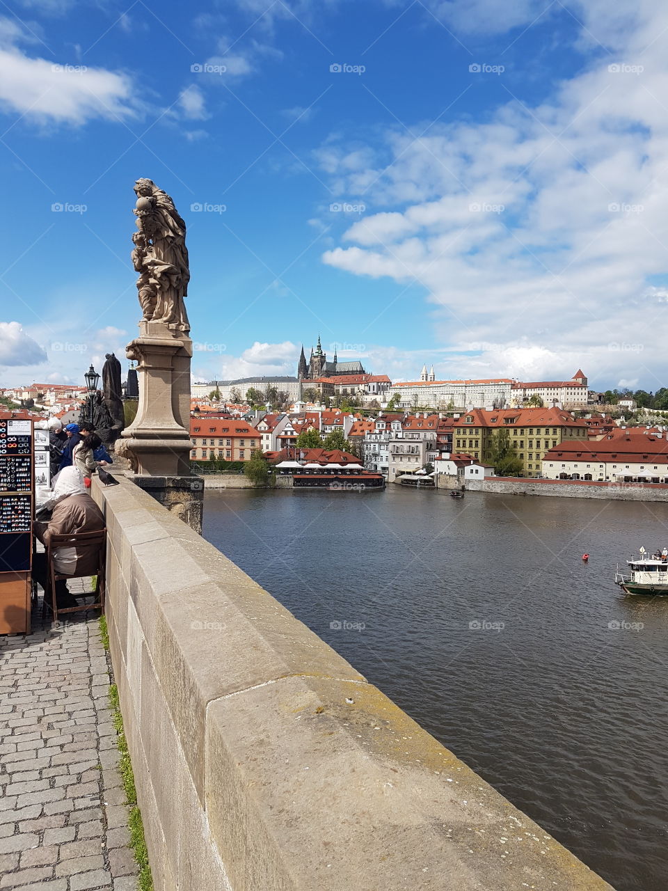 a view from Charles bridge. looking across the river and the castle, rising high from the horizon, in clear view