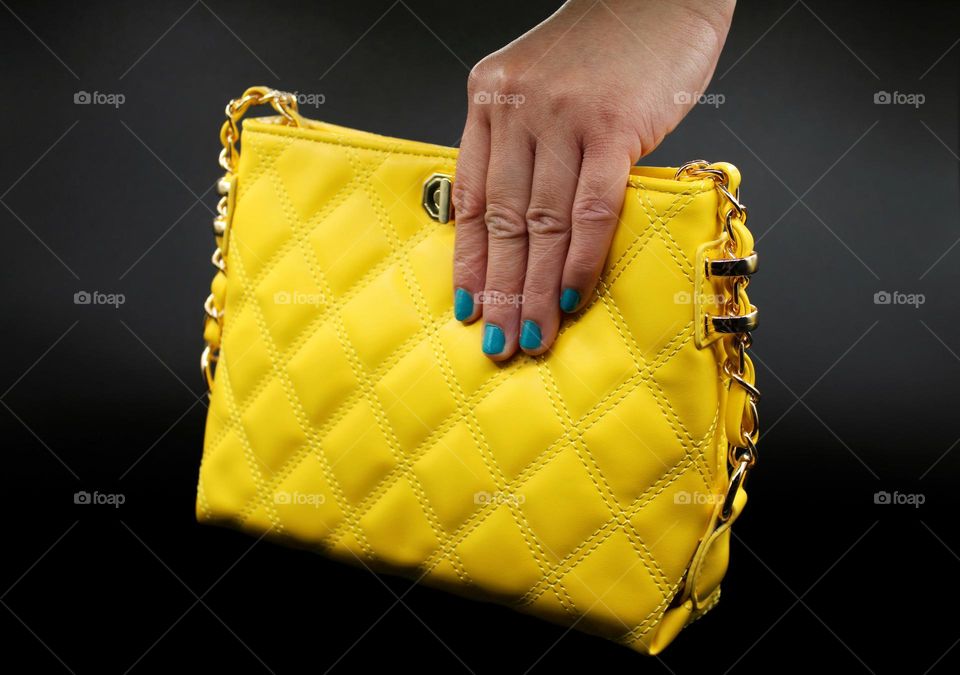 the hand and yellow bag